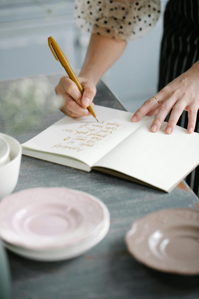 Person journaling at table creating a safe space for emotional reflection and healing