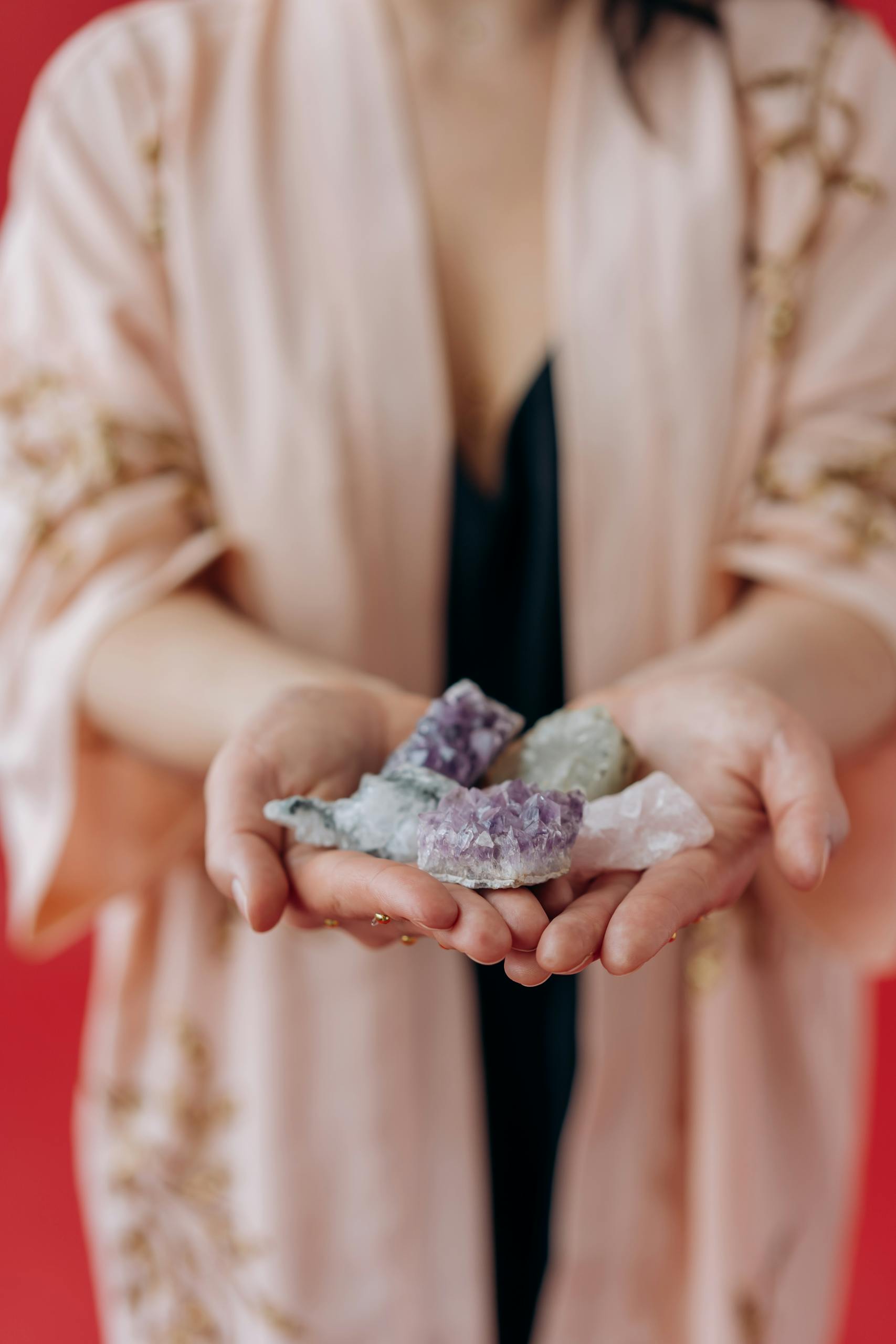 A woman gently holds healing crystals in her hands, focusing on positive energy and mindfulness.