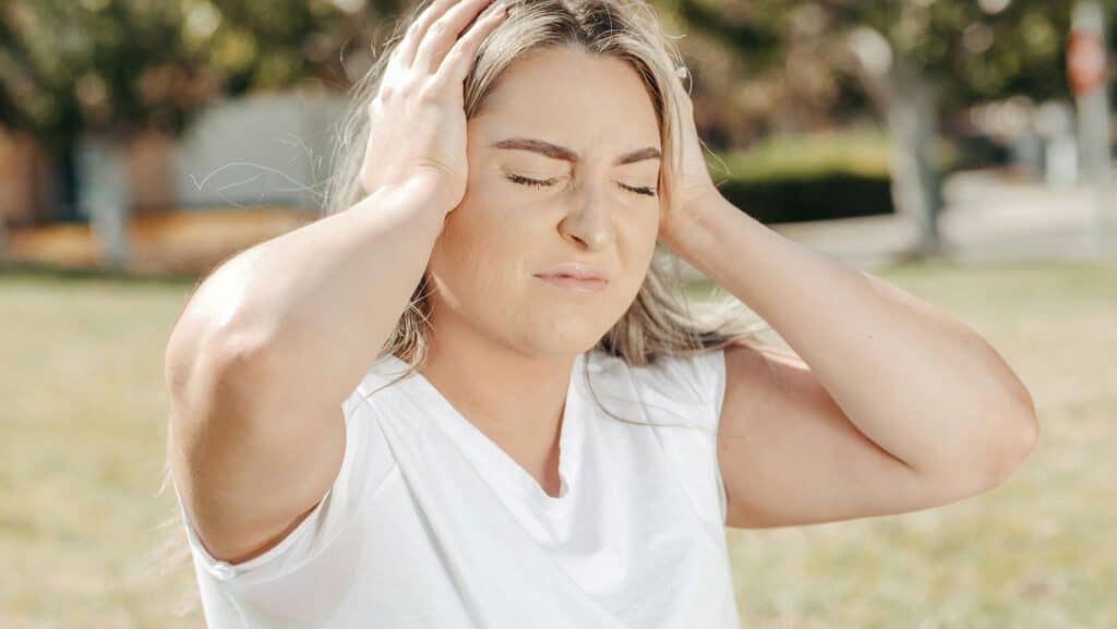 woman holding head showing headache might need energy healing